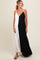 woman wearing a black and white color block maternity dress with spaghetti straps and a flowy silhouette