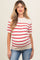 woman wearing a beige maternity top with red stripes and a visible baby bump, paired with blue jeans