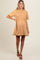 woman wearing a tan short sleeve maternity dress with a flared skirt and visible baby bump