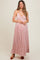 woman wearing a pink pleated maternity dress with floral print and spaghetti straps