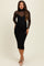 woman wearing a black maternity dress with a fitted design and sheer long sleeves, displaying a baby bump