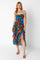 woman wearing a floral print tiered sundress with a high slit and adjustable straps