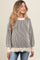 woman wearing a striped cream and black maternity sweater with balloon sleeves and a relaxed fit