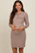 woman wearing a taupe ribbed maternity dress with a buttoned collar and pocket, gently cradling her baby bump