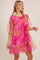 woman wearing a pink floral sheer dress with puff sleeves and a gathered neckline