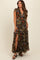 woman wearing a floral print maternity maxi dress with short sleeves and a thigh-high slit