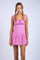 woman wearing a pink floral short dress with a fitted bodice and tiered ruffle hem