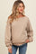 woman wearing a beige off-shoulder maternity sweatshirt with balloon sleeves and relaxed fit