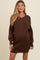 woman wearing a brown maternity sweater dress with buttons and balloon sleeves, showing her baby bump