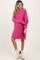 woman wearing a hot pink oversized knitted maternity dress with side slits and long sleeves