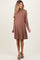 woman wearing a brown long sleeve maternity dress with a relaxed silhouette and a visible baby bump