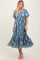 woman wearing a blue floral embroidered midi dress with puff sleeves and a tiered skirt