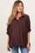 woman wearing a maroon checkered maternity shirt with rolled sleeves and a relaxed fit, showing her baby bump