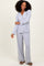 woman wearing a light gray long sleeve pajama set with button-up top and wide-leg bottoms