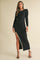 woman wearing a black ribbed knit dress with long sleeves and a side slit, styled with black strappy heels