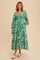 woman wearing a green floral maxi dress with puff sleeves and a square neckline, standing against a beige background