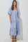 woman wearing a flowy lavender floral maxi dress with puff sleeves and tiered design, standing with hands in pockets