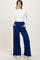 woman wearing a white long sleeve top and navy blue wide-leg pants with pockets and a drawstring waist