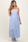 woman wearing a light blue striped maternity maxi dress with thin straps and a flowing skirt, holding her hair