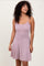 woman wearing a light pink ribbed spaghetti strap dress with a flared skirt