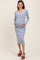 woman wearing a striped blue maternity dress with buttons, highlighting her baby bump