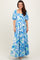 woman wearing a blue floral maxi dress with puff sleeves and a tie waist