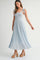 woman wearing a light blue pleated maxi dress with adjustable tie straps and platform wedge heels