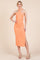 woman wearing an orange ribbed halter neck midi dress with a side slit and gathered detailing