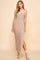 woman wearing a beige striped spaghetti strap maxi dress with a side slit and fitted silhouette