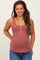 woman wearing a rust-colored maternity tank top with button details and a visible baby bump