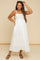woman wearing a white polka dot maternity maxi dress with spaghetti straps and a baby bump