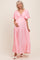 woman wearing a pink puff sleeve maternity maxi dress and holding her baby bump