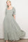 woman wearing a green floral maxi dress with puff sleeves and a square neckline, styled with a flowing skirt