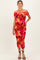 woman wearing a vibrant orange and pink floral off-the-shoulder maternity dress with a visible baby bump