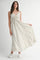 woman wearing a long floral maxi dress with a tied front detail and flowing skirt, paired with white sneakers