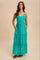 woman wearing a teal tiered maxi dress with adjustable straps and side pockets