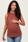 woman wearing a rust ribbed maternity tank top with ruffle details and holding her baby bump