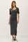 woman wearing a fitted charcoal gray midi dress with short sleeves and side slits, paired with black high-top sneakers