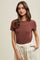 woman wearing a brown short sleeve tee paired with cream-colored drawstring pants