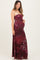 woman wearing a burgundy floral strapless maternity maxi dress and holding her baby bump