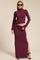woman wearing a burgundy two-piece long sleeve top and high waist maxi skirt with a side slit and sunglasses