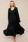 woman wearing a black long sleeve tiered maxi dress with a smocked bodice and flowy skirt