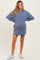 woman wearing a blue maternity sweatshirt dress with long sleeves and a visible baby bump