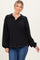 woman wearing a black oversized pullover with a collar and front pocket, styled with blue jeans