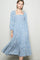 woman wearing a light blue floral long sleeve maxi dress with a square neckline and flowy skirt