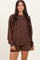 woman wearing a brown long sleeve oversized sweatshirt and matching shorts