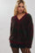 woman wearing a burgundy and green checkered oversized v-neck sweater paired with a black mini skirt