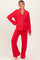 woman wearing a red maternity pajama set with white piping and a visible baby bump