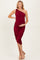 woman wearing a burgundy one-shoulder ruched maternity dress and holding her baby bump