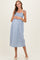 woman wearing a light blue striped maternity dress with adjustable tie straps and a visible baby bump